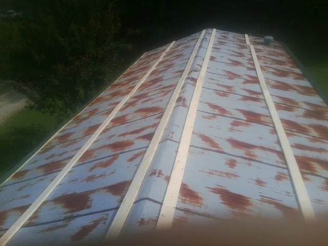 Rusted metal roof panels with new wood purlins before replacement — Storm Damage Roof Repair in Piermont by Roofing Brothers