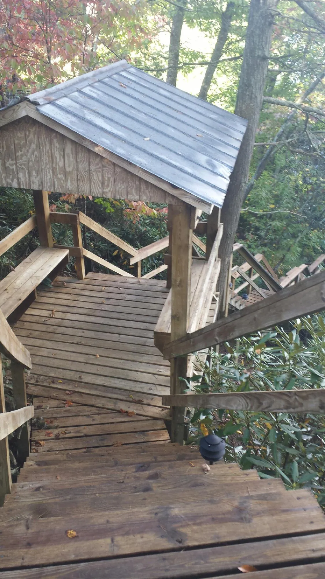 Metal roofed shelter over wooden steps on a wooded walkway — Skylight Repair & Installation work by our crew in Piermont