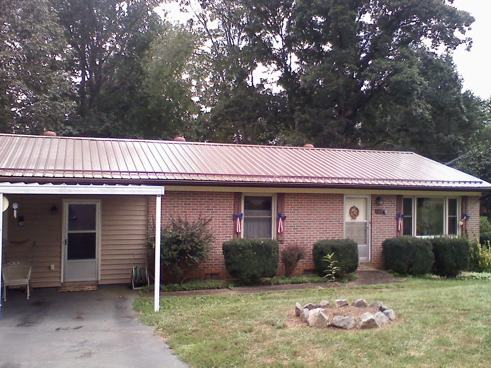 Bronze metal roof and carport on a brick ranch home — Roof Repair work by our crew in Piermont